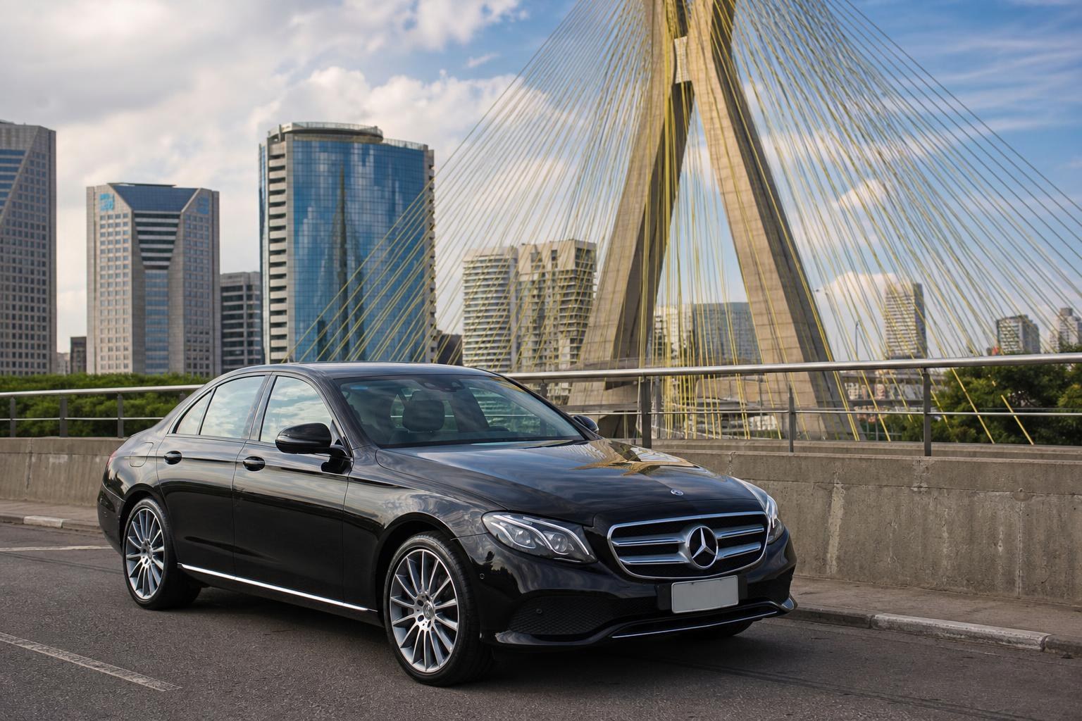 Revisão de Mercedes em SP: Conheça as Opções Black Mercedes-Benz sedan parked on a bridge in São Paulo with the Octávio Frias de Oliveira cable-stayed bridge and skyscrapers in the background.